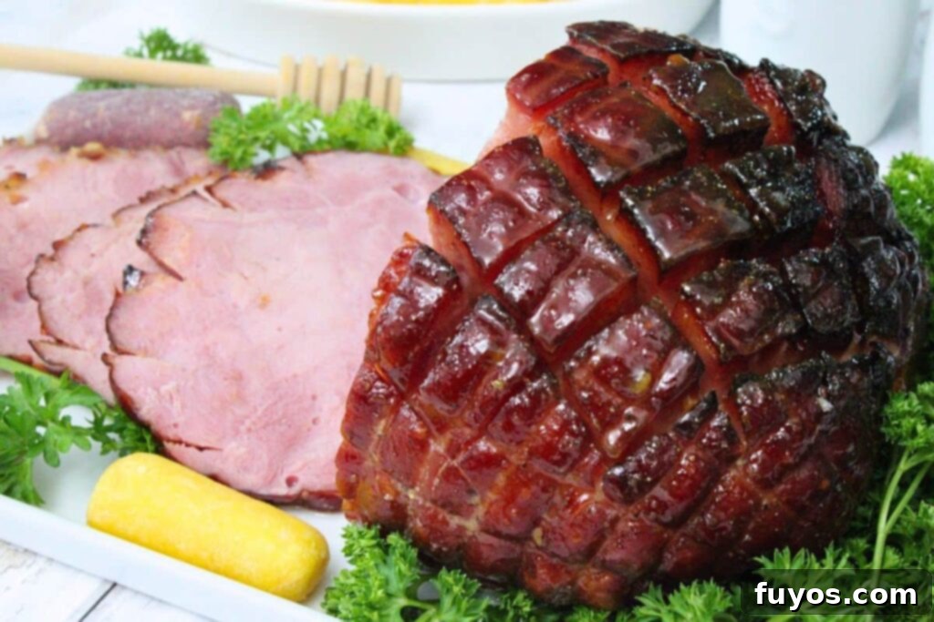 View of the back of a cut small ham cooked in the air fryer showing off the honey glaze and caramelized edges