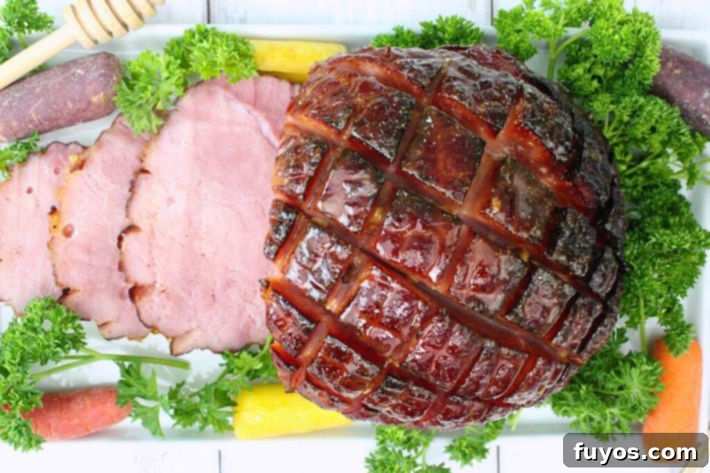 Overhead view of hot honey glazed small ham sliced showing caramelized edges and pinecone cut on a bed of parsley and carrots