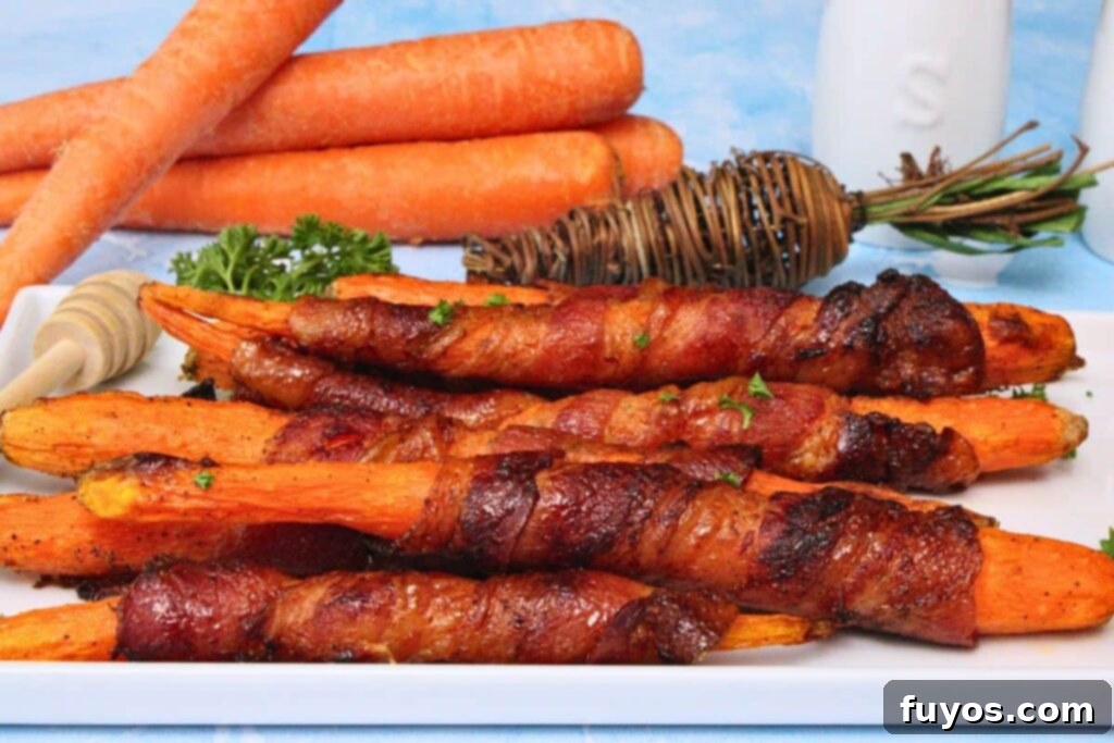Air Fryer Bacon-Wrapped Carrots Drizzled with Hot Honey 3 Closeup view of bacon wrapped carrots on a white serving plate with fresh carrots in the back