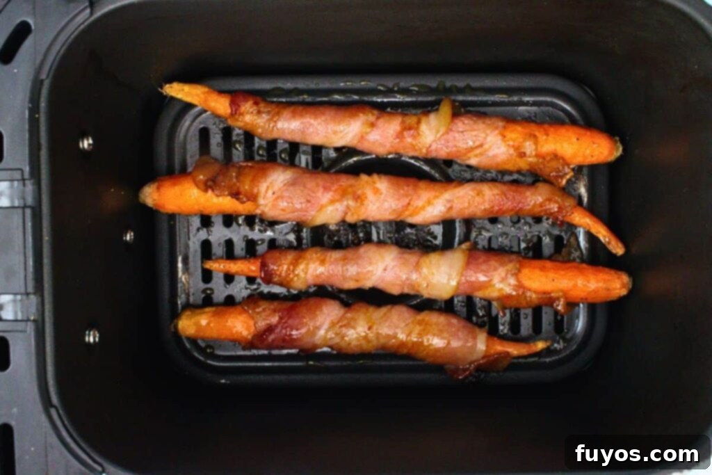 Air Fryer Bacon-Wrapped Carrots Drizzled with Hot Honey 8 Brush hot honey on bacon wrapped carrots and caramelize glaze