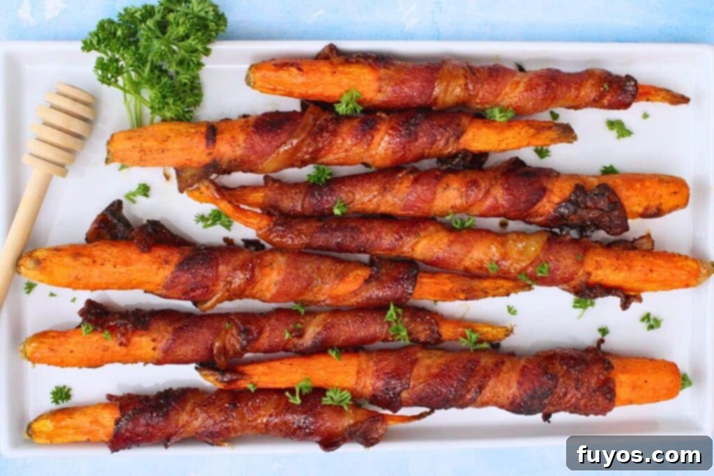 Air Fryer Bacon-Wrapped Carrots Drizzled with Hot Honey 9 Overhead view of air fryer bacon wrapped carrots on a white platter with fresh parsley