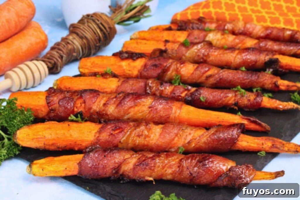 Air Fryer Bacon-Wrapped Carrots Drizzled with Hot Honey 10 Bacon wrapped carrots lined across black slate with fresh carrots in the background