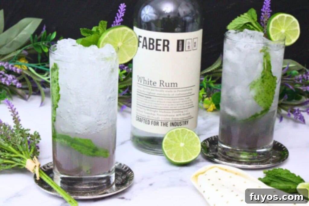 Lavender Mojito: Aromatic Spring Refresher 3 Two lavender mojitos in tall glasses with crushed ice, garnished with lime wheel and mint, surrounding a rum bottle, showcasing the drink's refreshing appeal.