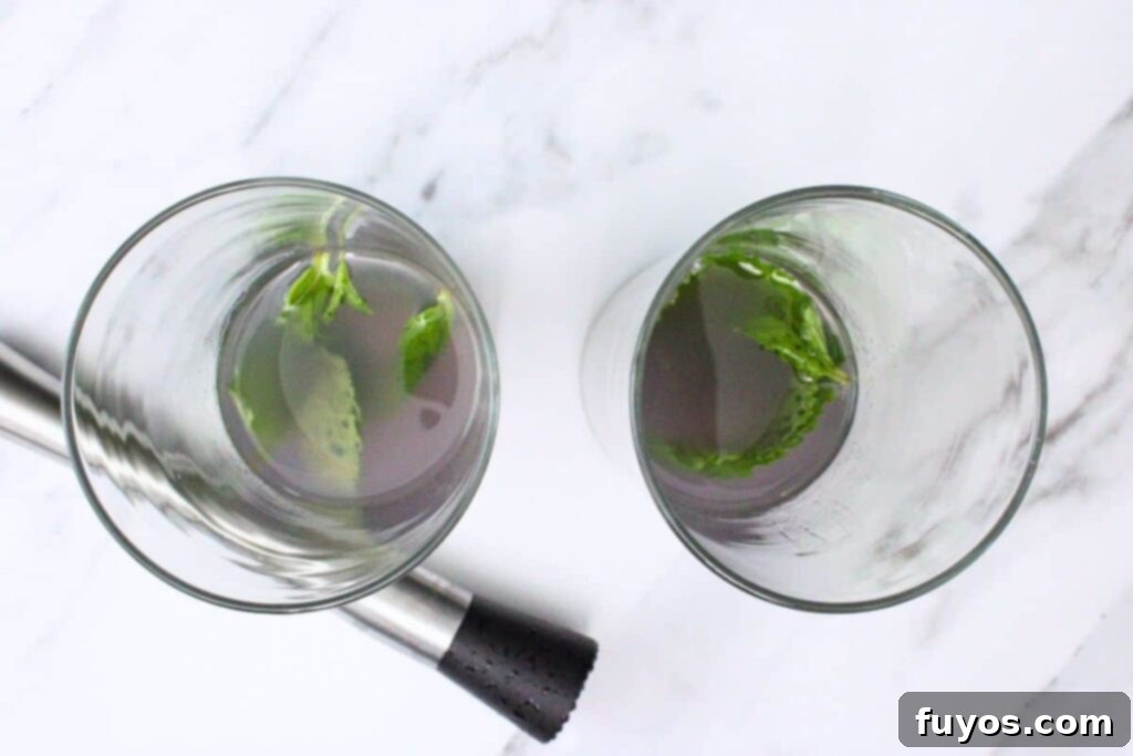 Lavender Mojito: Aromatic Spring Refresher 5 Adding mint, lavender syrup, lime juice, and rum to a highball glass as the first step in making a lavender mojito.