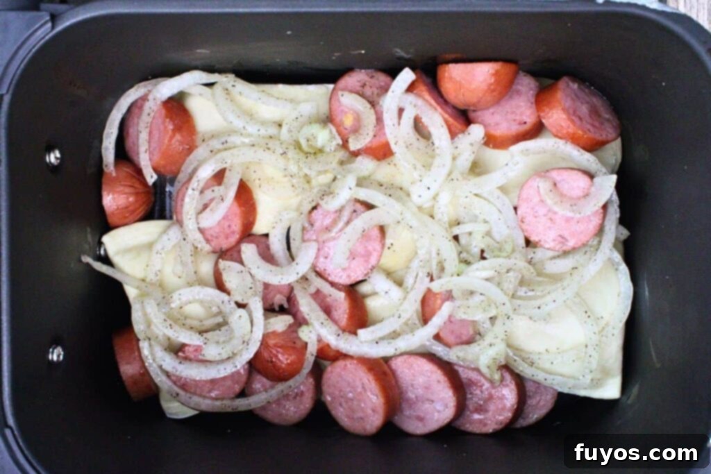 Add sliced onions to kielbasa and pierogies